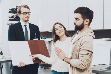 Çift istemcilerine mutfak mağazasında farklı malzeme dolapları için gösterilen takım yöneticisi