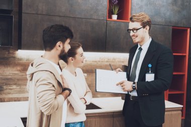 Mutfak mağazasında çift istemcilere mutfak planları gösterilen takım yöneticisi