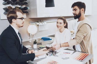 Çift istemcilerine mutfak mağazasında farklı malzeme gösterilen takım yöneticisi