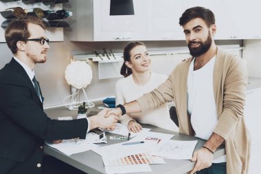 Takım elbise ve mutfak mağazasında tokalaşırken karısı ile istemci Yöneticisi