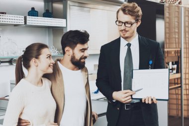 Mutfak mağazasında çift istemcilere mutfak planları gösterilen takım yöneticisi