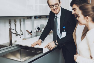 Evye kapaklı mutfak mağazasında çift istemcilere gösterilen takım yöneticisi