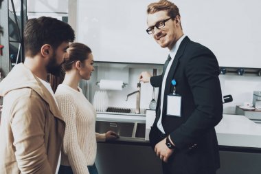 Evye kapaklı mutfak mağazasında çift istemcilere gösterilen takım yöneticisi