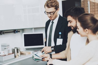 Mutfak mağazasında çift istemcilere renkli renk örnekleri gösterilen laptop ile takım yöneticisi