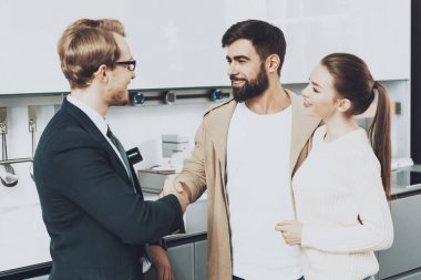 Takım elbise ve mutfak mağazasında tokalaşırken karısı ile istemci Yöneticisi