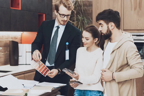 Mutfak mağazasında çift istemcilere renkli palet gösterilen takım yöneticisi