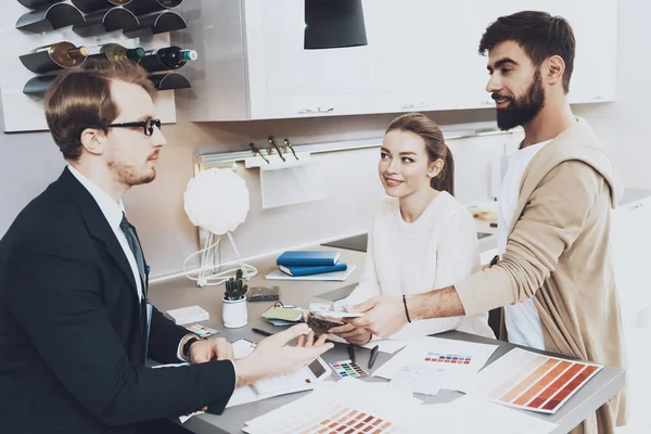 Çift istemcilerine mutfak mağazasında farklı malzeme gösterilen takım yöneticisi