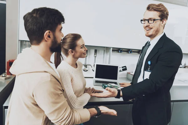 Takım elbise ve dizüstü bilgisayar ile mutfak mağazasında yeni mutfak arka plan üzerinde tartışırken karısı ile istemci Yöneticisi