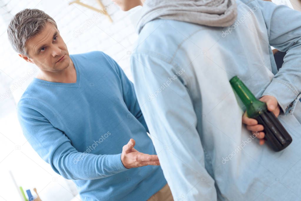 Angry drunk father asking his son giving back his beer