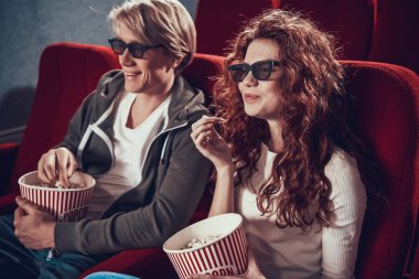 Adam ve kadın oturmuş film izliyorlar.