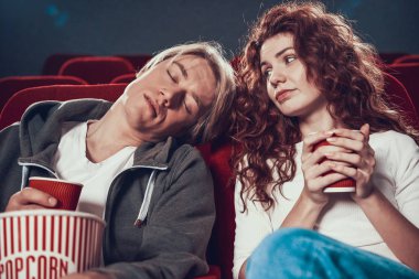 Adam ve kadın oturmuş film izliyorlar.