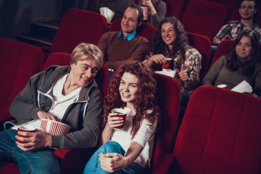 İnsanlar sinemada oturup birlikte film izliyorlar..