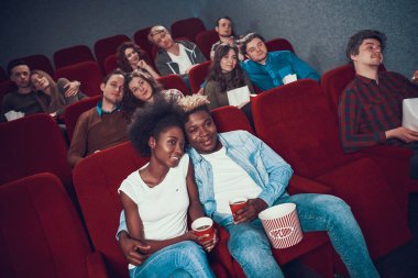 İnsanlar sinemada oturup film izliyorlar..