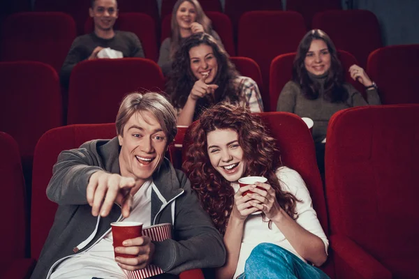 People sit in the cinema and watch movie together.