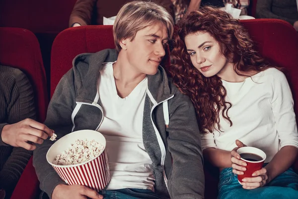 Loving couple sit holding hands in cinema. — Stock Photo, Image