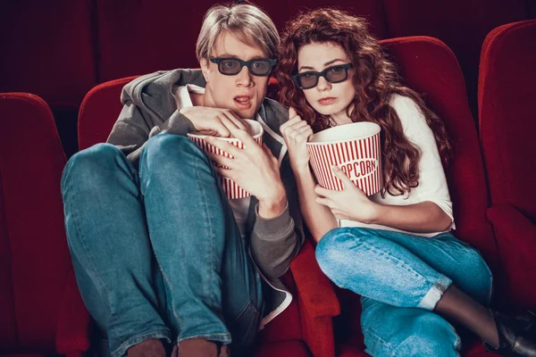 Guy y la mujer están sentados y viendo una película Imagen De Stock