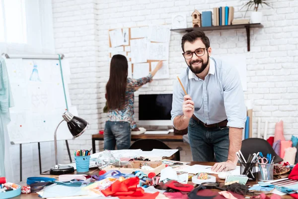 Männlicher Designer Mit Skizzenvorlage Während Frau Schneiderei Mit Aufträgen Arbeitet — Stockfoto