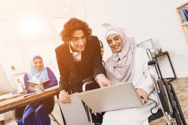 Arap kadın ile erkek iş arkadaşınız konuşuyor tekerlekli sandalyede hijab devre dışı