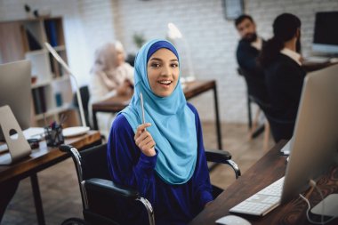 Arap kadın Türban masaüstü bilgisayarda çalışan tekerlekli sandalyede devre dışı