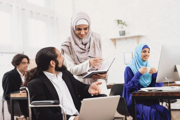 Fogyatékkal Élő Arab Férfi Öltönyt Tolószékben Női Munkatársa Beszélgetett — Stock Fotó