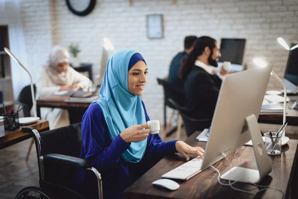 Gehandicapte Arabische Vrouw Hijab Rolstoel Bezig Met Desktopcomputer Koffie Drinken — Stockfoto