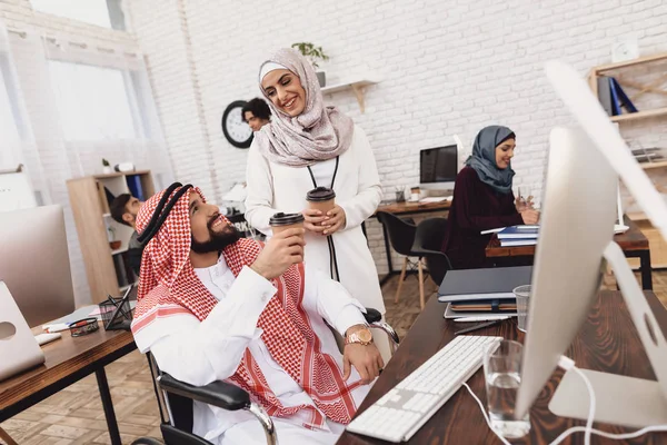 Behinderter Arabischer Mann Rollstuhl Trinkt Kaffee Mit Mitarbeiterin — Stockfoto