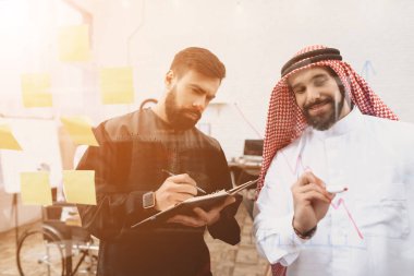İki Arap adam notlar cam tahta üzerinde çalışma