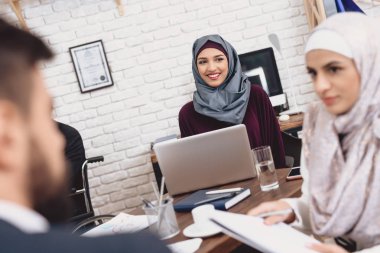 Notlar tartışırken tekerlekli sandalyede takım elbiseli Arap adam devre dışı