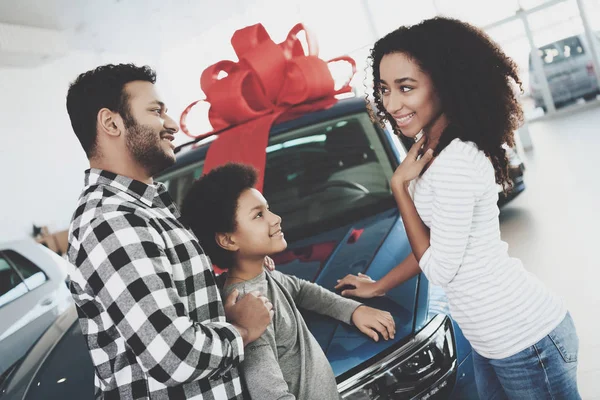 African american family in car dealership choosing and buying new car