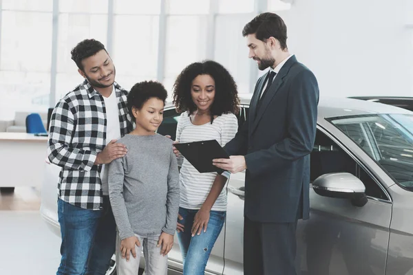非洲裔美国人家庭签署文件为新汽车在汽车经销商 — 图库照片