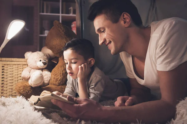 Отец Сын Читают Книгу Дома Полу — стоковое фото