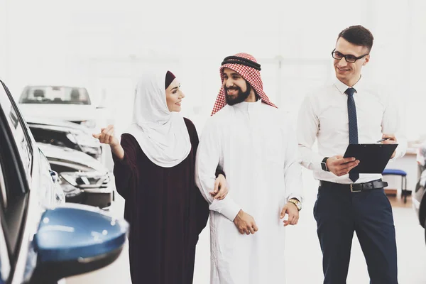 推销员帮助选择新的汽车到阿拉伯夫妇在汽车经销商 — 图库照片
