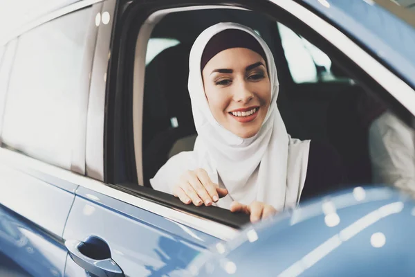 Arabic woman sitting in new auto at car dealership