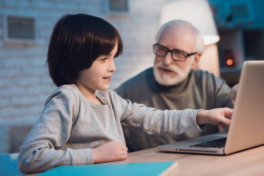 Dede ve torunu masada dizüstü film izlerken