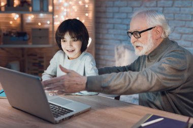 Dede ve torunu masada dizüstü film izlerken