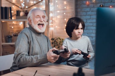 Grandfather and grandson playing video games at home clipart