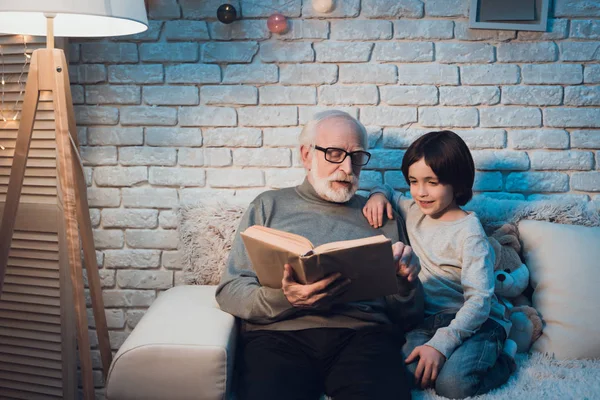 Dedesi ve masal okuma torunu evde kanepede kitap
