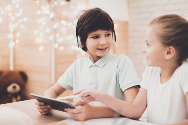 Masada oturan ve kullanarak kardeş evde tablet