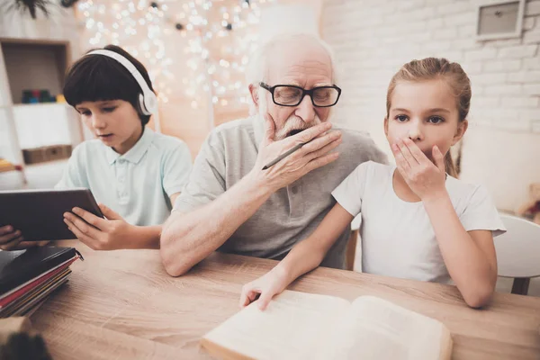 Abuelo Ayudando Niño Con Tarea Mientras Que Niña Usando Tableta — Foto de Stock