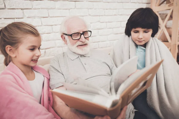 Abuelo Los Niños Viendo Fotos Álbum Sofá Casa —  Fotos de Stock