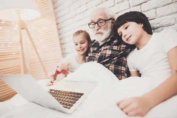 Abuelo Los Niños Acostados Cama Utilizando Ordenador Portátil — Foto de Stock