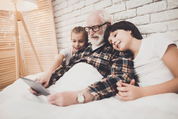 Büyükbaba Çocuk Yatakta Tablet Kullanma — Stok fotoğraf