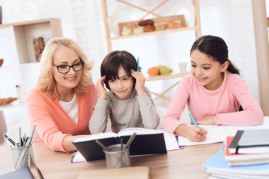 Büyükanne torunları ile masada ödev yardım