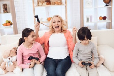 kanepede oturan ve torunları ile video oyunları oynarken büyükanne  