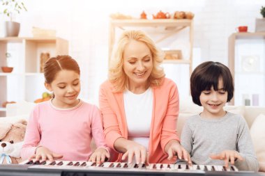 yaşlı kadın üzerinde synthesizer oynarken torun öğretim