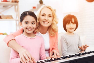 yaşlı kadın üzerinde synthesizer oynarken torun öğretim