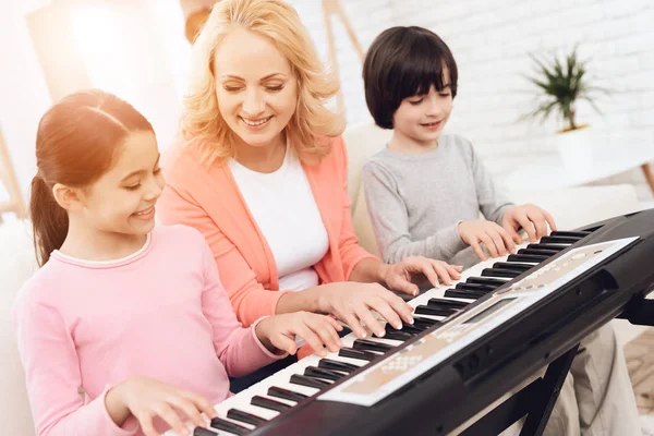 yaşlı kadın üzerinde synthesizer oynarken torun öğretim