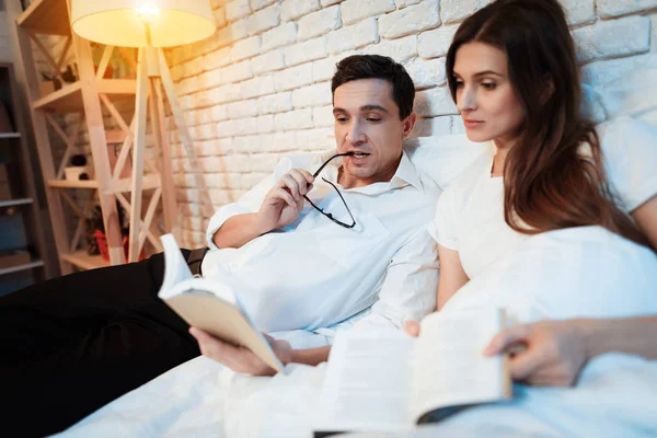 男人和他的妻子在床上看书和讨论商业飞机 — 图库照片