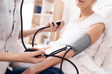 Yaşlı kadın Hemşirelik ve kan basıncı ölçmek için tonometer kullanarak kız