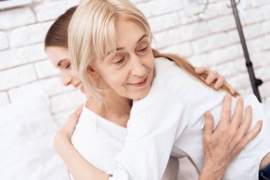 Yatakta ve onlar birbirlerine kucaklayan Hemşirelik yaşlı kadın kız